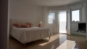 A bedroom with a bed, a bedside lamp, a TV, and a view of the outdoors. - Luxurious 3 bedroom villa with stunning panoramic views in Denia (Denia)