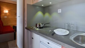 A compact kitchen with a microwave, stove, and sink. - Renovated and Comfortable Studio · Heart of Resort (Plagne Bellecôte)