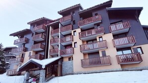 A multi-story hotel with wooden balconies and a stone facade.