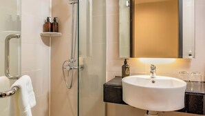 A modern bathroom with a glass-enclosed shower, a white sink, and a large mirror. - Centrestage Petaling Jaya- Perfect Host (Petaling Jaya)