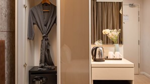 A hotel room with a robe hanging on a rack, a coffee maker, and a small refrigerator. - Centrestage Petaling Jaya- Perfect Host (Petaling Jaya)