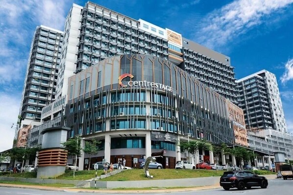 A modern hotel with a curved facade, multiple floors, and a prominent entrance.