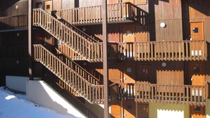 A wooden building with multiple balconies and a staircase.
