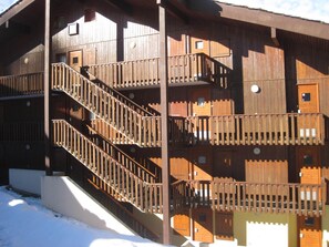 Un bâtiment en bois doté de plusieurs balcons et d’un escalier.