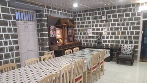 A dining area with a long table, chairs, and a decorative cabinet.