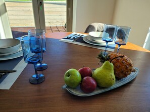 A dining table with a fruit platter, glasses, and cutlery. - Cozy apartment in pleasant surroundings (Alcacer do Sal)