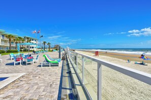 A beachside hotel with a pool area, lounge chairs, and a view of the ocean. - Oceanfront Couples Retreat - 5 Steps to Pool (Daytona Beach)