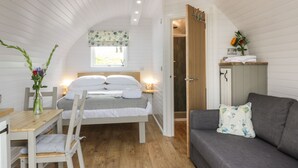 A cozy bedroom with a bed, bedside table, chair, and a sofa. - Laird Lodge 3 (Lochmaben)