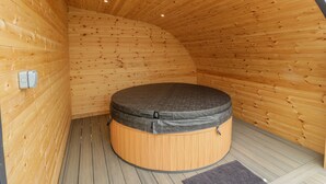A wooden cabin with a circular hot tub in the center. - Laird Lodge 2 (Lochmaben)