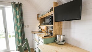 A compact kitchen with a wooden table, a sink, and a microwave. - Laird Lodge 5 (Lochmaben)