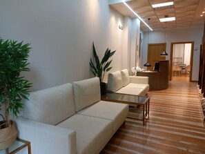 A modern interior with a sofa, a glass coffee table, and a reception desk.