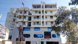 Un edificio de varios pisos con carteles que dicen 'Nidaan', 'SpaStar Wellness Studio' y 'Clínica del Corazón'.
