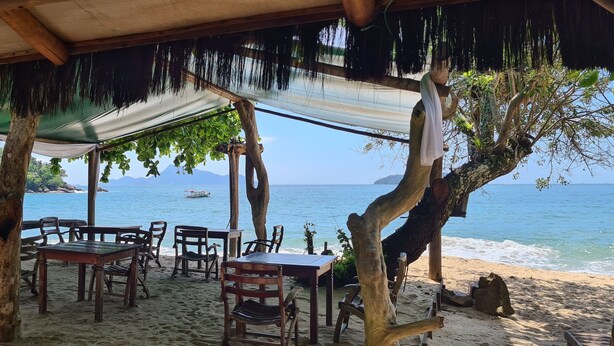 A beachside wooden structure with tables and chairs, overlooking the sea. - Cabanas Paraiso (Angra dos Reis)