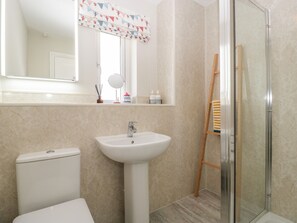 Une salle de bain avec des toilettes, un lavabo et une douche.