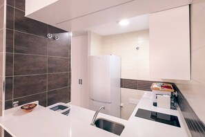 A modern kitchen with a white countertop, a built-in sink, and a refrigerator. - Yaye House, Écija (Ecija)