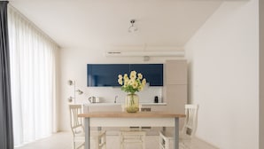 A modern kitchen with a dark blue cabinet, a white countertop, and a vase with flowers. - App 6 - Centrale Mazzoni (Venecia)