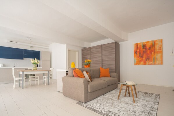 A modern living room with a sofa, coffee table, and a painting on the wall. - App 6 - Centrale Mazzoni (Venecia)