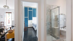 Ein modernes Badezimmer mit Duschabtrennung aus Glas, einer Badewanne und einem weißen Waschbecken.