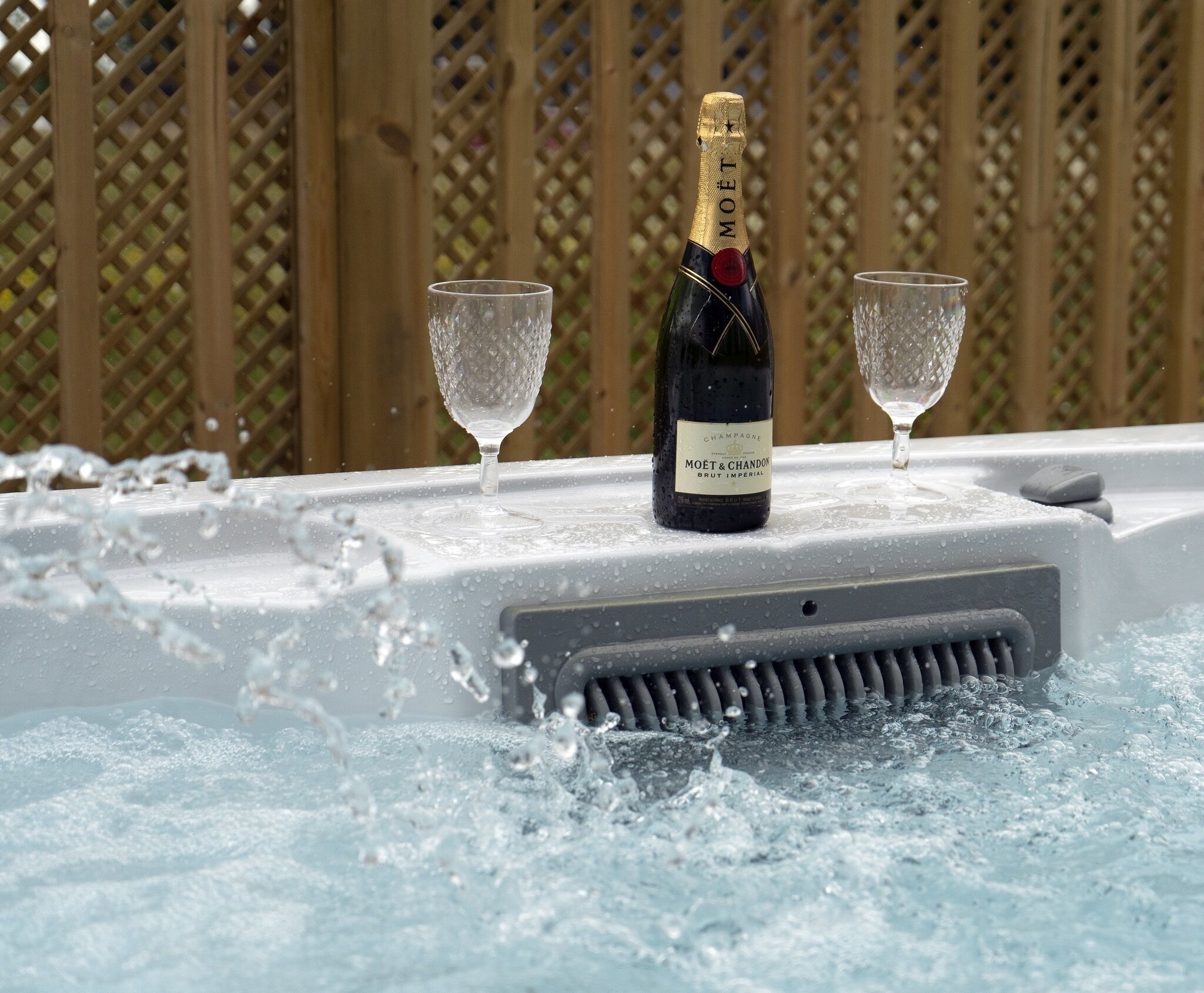 A bottle of Moët & Chandon Brut Imperial champagne on a table with two glasses.
