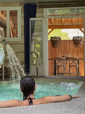 A person relaxing in a pool with a view of wooden furniture and a hanging light fixture. - La Maison Mulato Bordeaux, Saint-emilion (Libourne)