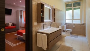 A modern bathroom with a large vanity, a toilet, and a shower area. - Lady Hill (Taormina)