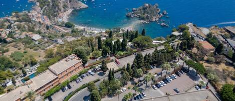 Vista aérea de una zona costera con edificios, un estacionamiento y una playa.