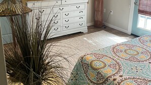 A bedroom with a bed, a dresser, a television, a ceiling fan, and a potted plant. - Welcome to Your New "HAPPY PLACE"   on your Island get away! (Navarre)