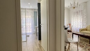 A modern interior with a hallway leading to a dining area and a living room.