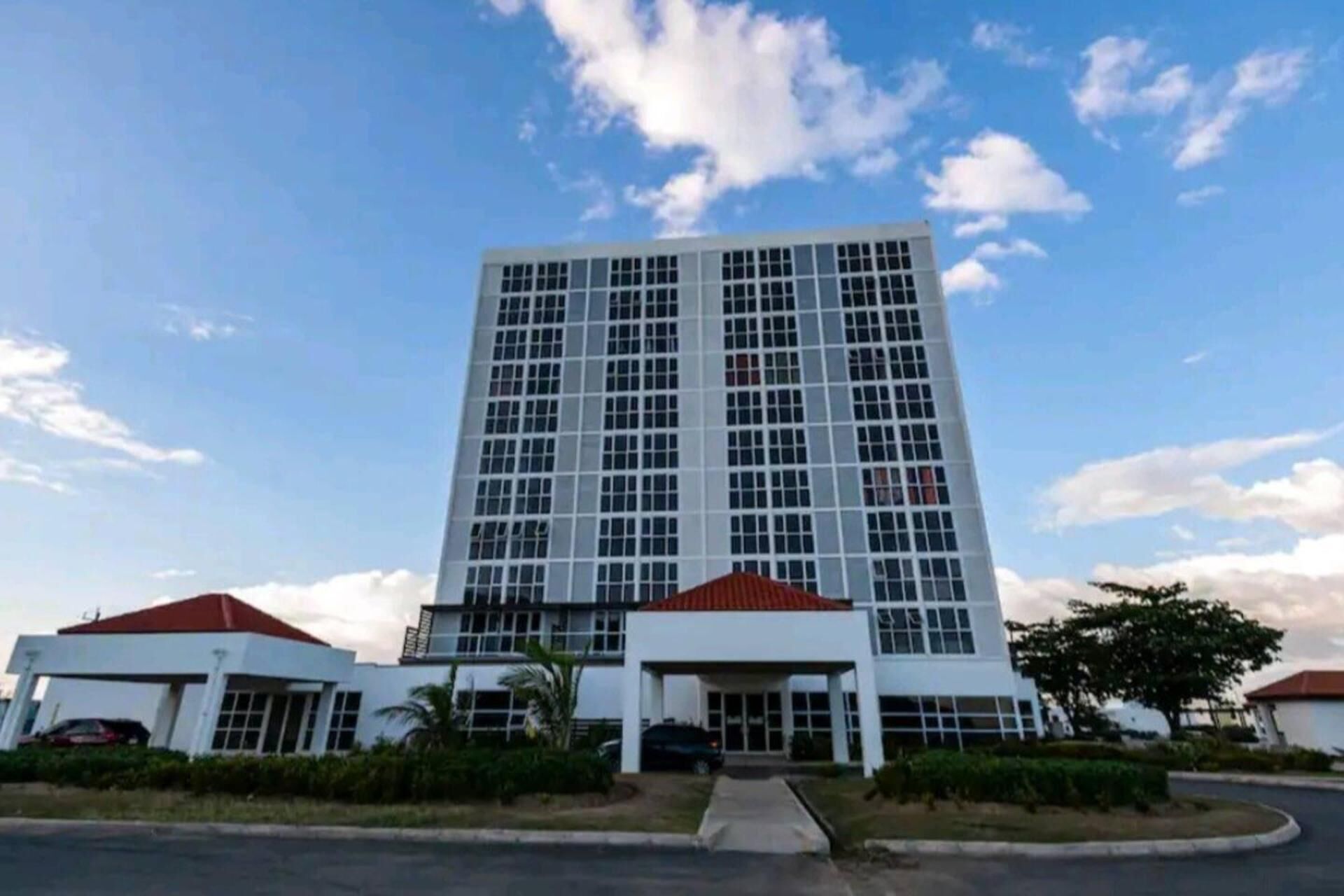 A modern multi-story building with a central entrance and two smaller wings.