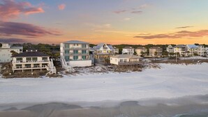 A beachfront property with multiple buildings, including a large house with a balcony and a smaller house with a deck. - Gulf Views with Pool, Firepit and LSV (Santa Rosa Beach)