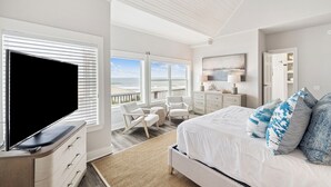 A bedroom with a large bed, a TV, a desk, and a chair. - Gulf Views with Pool, Firepit and LSV (Santa Rosa Beach)