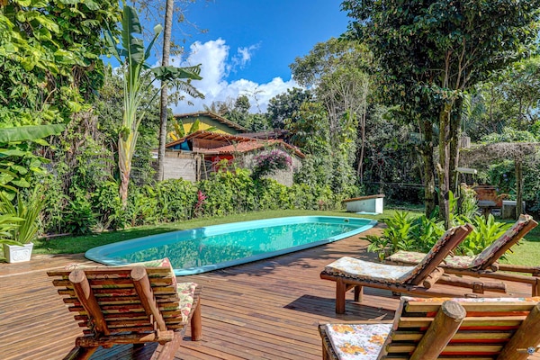 Una piscina al aire libre, sillones reclinables de piscina