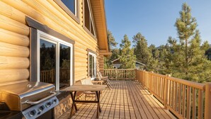 Une terrasse en bois avec un barbecue et des sièges d’extérieur.