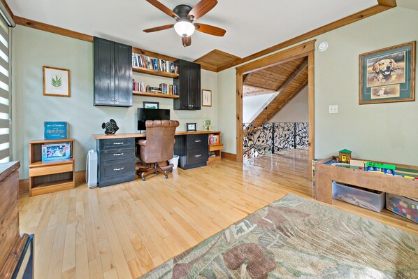A room with a wooden desk, a chair, a ceiling fan, and a bookshelf. - Lakefront Retreat | Luxury Home with Gorgeous VIEWS & Private Dock! (Nebo)