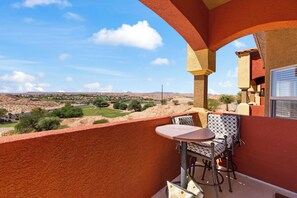 A balcony with a table and chairs, overlooking a landscape with greenery and distant hills. - About Time Oasis Mesquite Vacation Rental with Private Balcony with $510 of free daily activities (Mesquite)