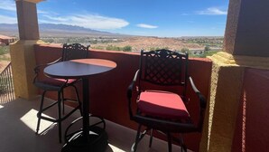 Patio esterno con due tavoli e sedie, affacciato su un paesaggio desertico con montagne sullo sfondo.