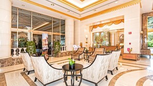 A lobby with a reception desk, seating area, and large windows.
