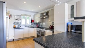 Una cucina moderna con pensili bianchi, un piano di lavoro in granito, elettrodomestici in acciaio inossidabile e una finestra con vista.