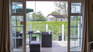 Een kamer met een schuifdeur naar een terras buiten, compleet met een tafel en stoelen.
