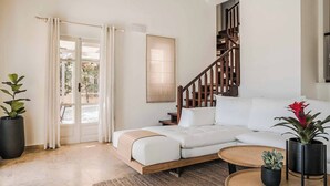 A modern living room with a sofa, a coffee table, and potted plants.