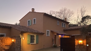 Une maison à deux étages, avec un toit en tuiles, des murs en pierre et le numéro « 199 » sur un portail.