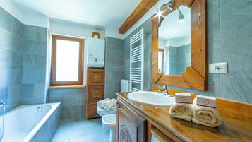 Appartement Familial, 1 chambre (Miramonti 21 Ski In - Ski Out) | Salle de bain | Baignoire et douche séparées, sèche-cheveux, bidet, serviettes fournies