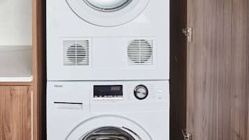 A stacked washer and dryer unit in a wooden cabinet.