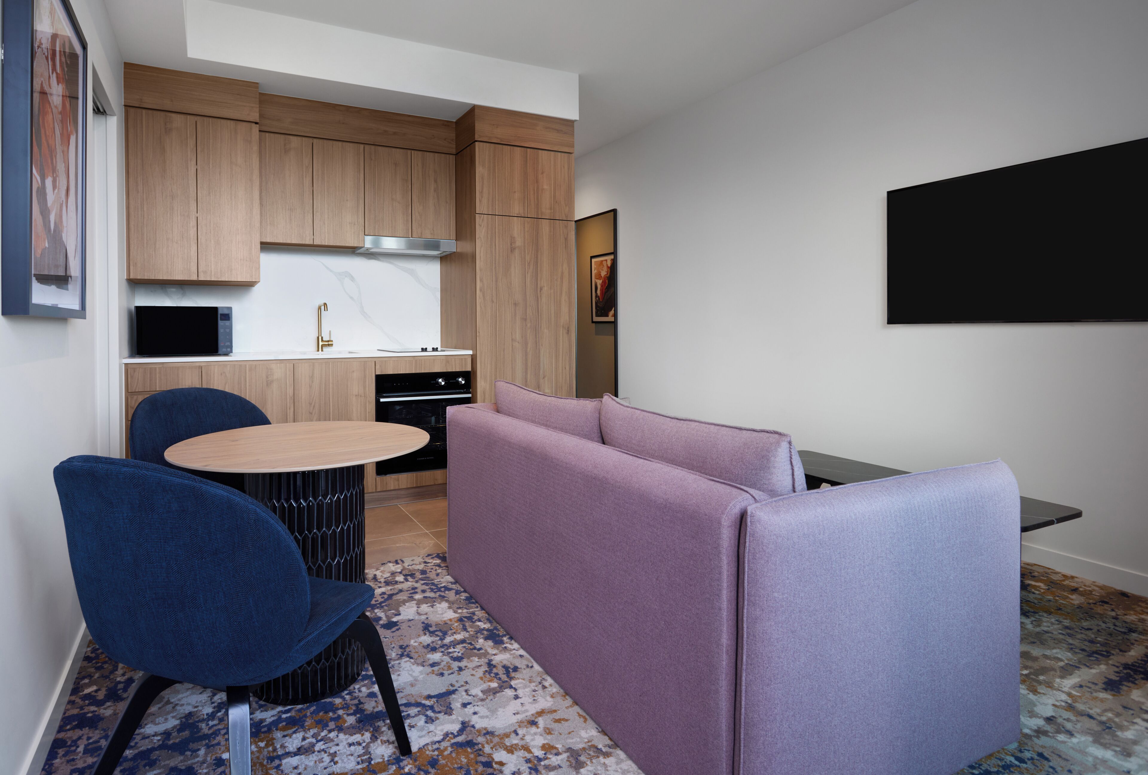 A compact kitchen with wooden cabinets, a built-in microwave, and a gas stove.