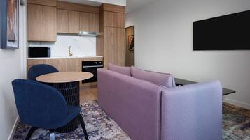 A compact kitchen with wooden cabinets, a built-in microwave, and a gas stove.