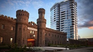 A historic building with a clock tower and a modern high-rise building in the background. - Adina Apartment Hotel Melbourne Pentridge (Coburg)