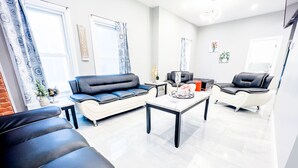 A modern living room with a sofa, a coffee table, and a chair. - The Griffon House (Niagara Falls)
