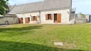 A stone building with a sloped roof and wooden shutters. - Gîte "Chez Nicole" in the heart of the Loire castles (Restigné)