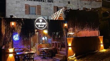 Un edificio que dice 'Assos Halici Han', con letreros que indican restaurante y cafetería.