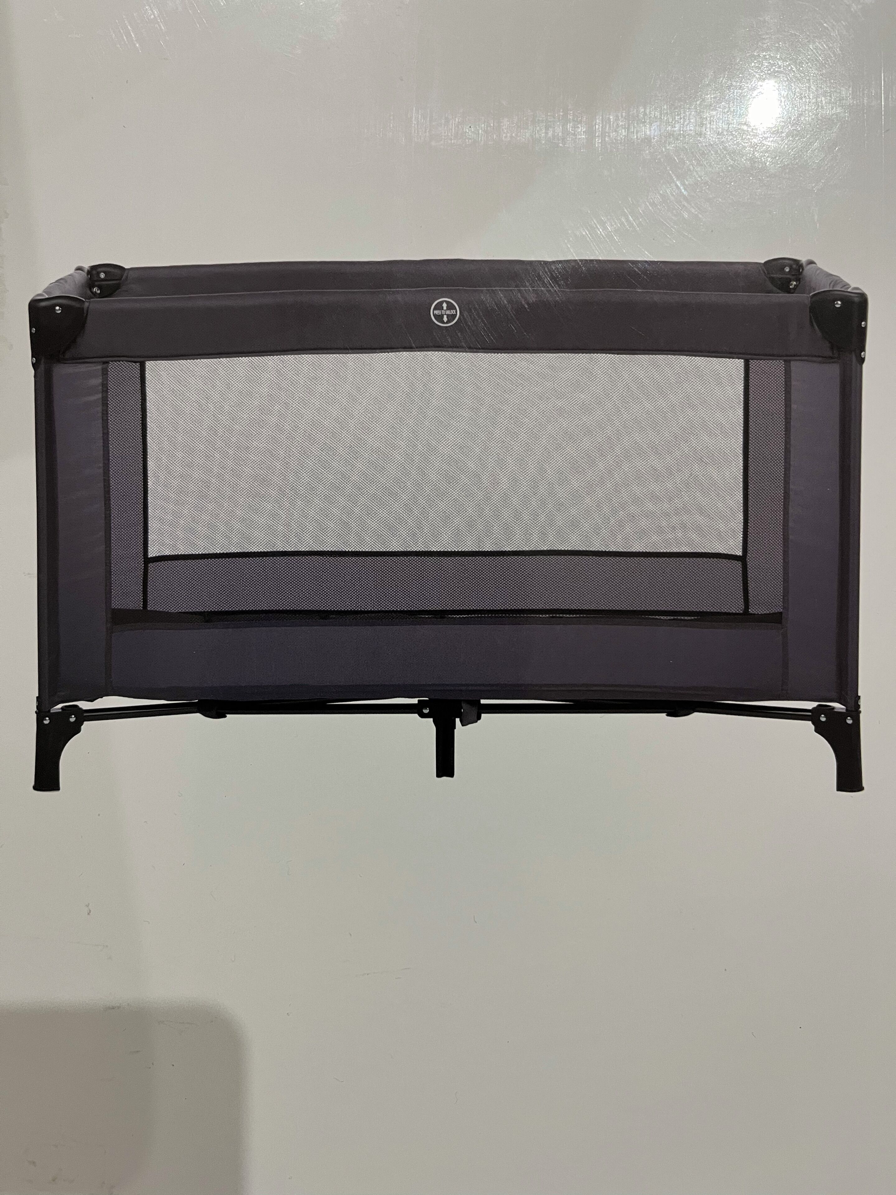 A black, rectangular, freestanding object with a mesh screen, likely a portable heater or air purifier, mounted on a black metal frame with four legs.